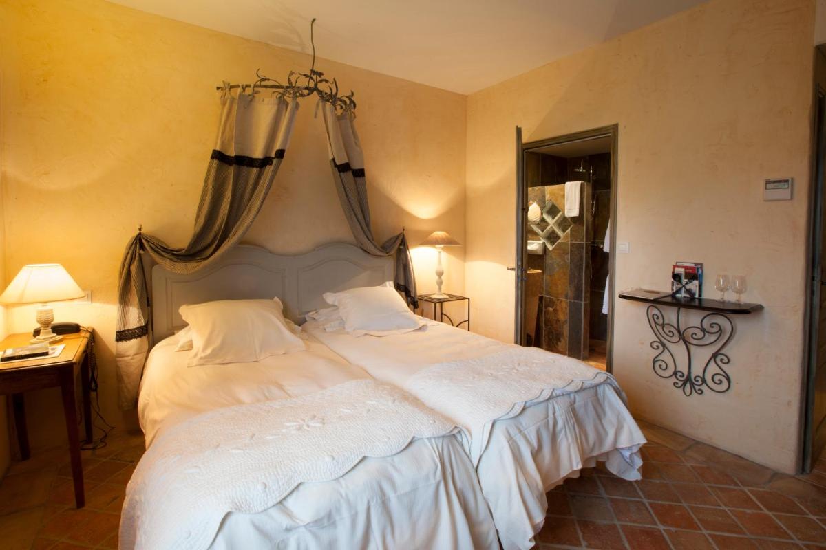 Un ou plusieurs lits dans un hébergement de l'établissement Hôtel-Spa Le Saint Cirq