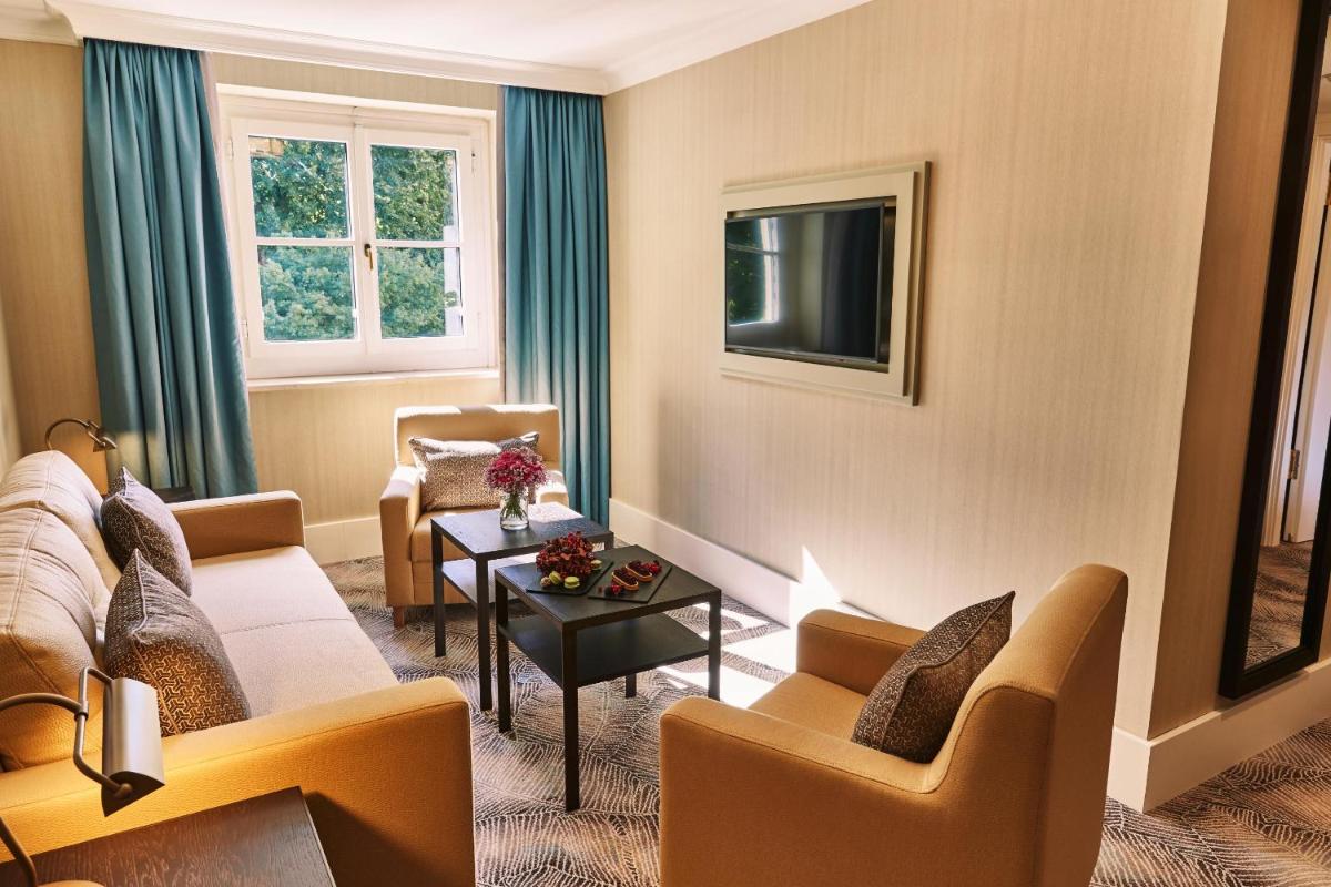 ein Wohnzimmer mit einer Couch und Stühlen und einem Tisch in der Unterkunft Steigenberger ICON Grandhotel & Spa Petersberg in Königswinter