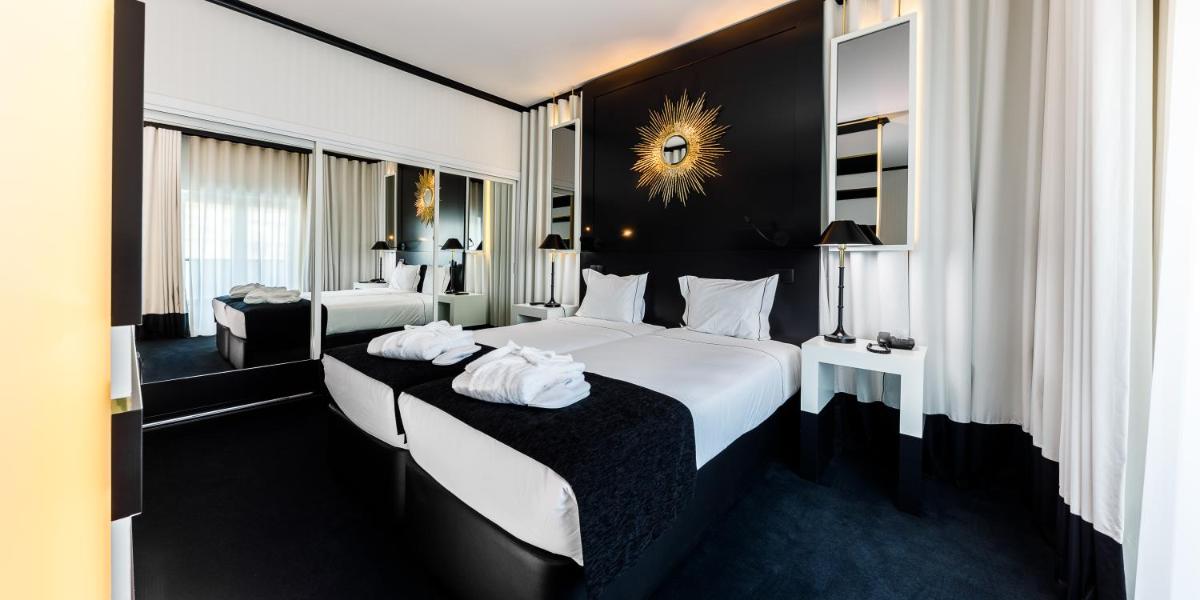 um quarto de hotel com duas camas com toalhas em Aurea Fatima Hotel Congress & Spa em Fátima