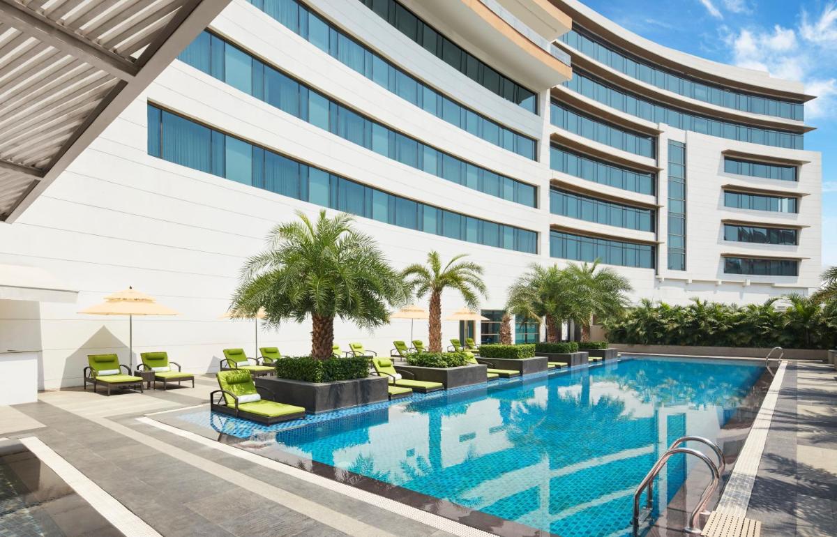 an exterior view of a hotel with a swimming pool at Taj Swarna, Amritsar in Amritsar