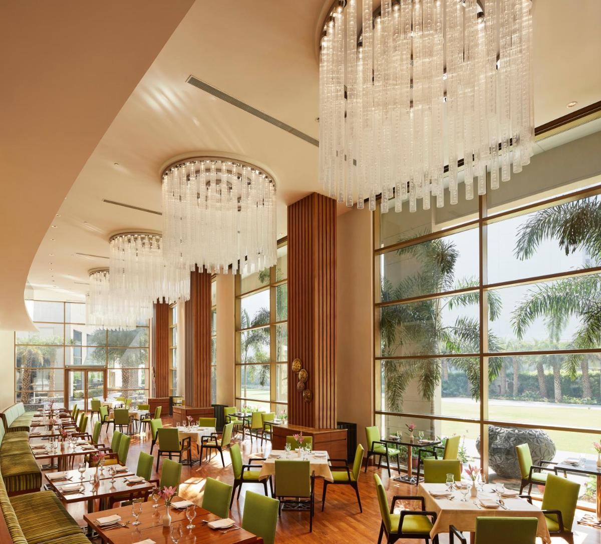 a dining room with tables and chandeliers at Taj Swarna, Amritsar in Amritsar