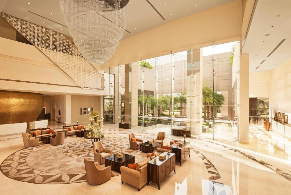a lobby of a hotel with couches and chairs at Taj Swarna, Amritsar in Amritsar