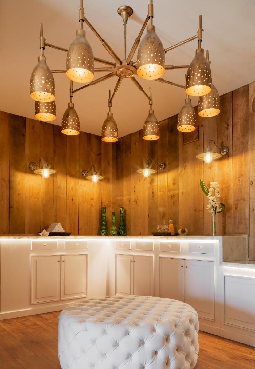 Una sala de estar con una otomana blanca bajo las luces. en H10 Playa Esmeralda - Adults Only, en Costa Calma