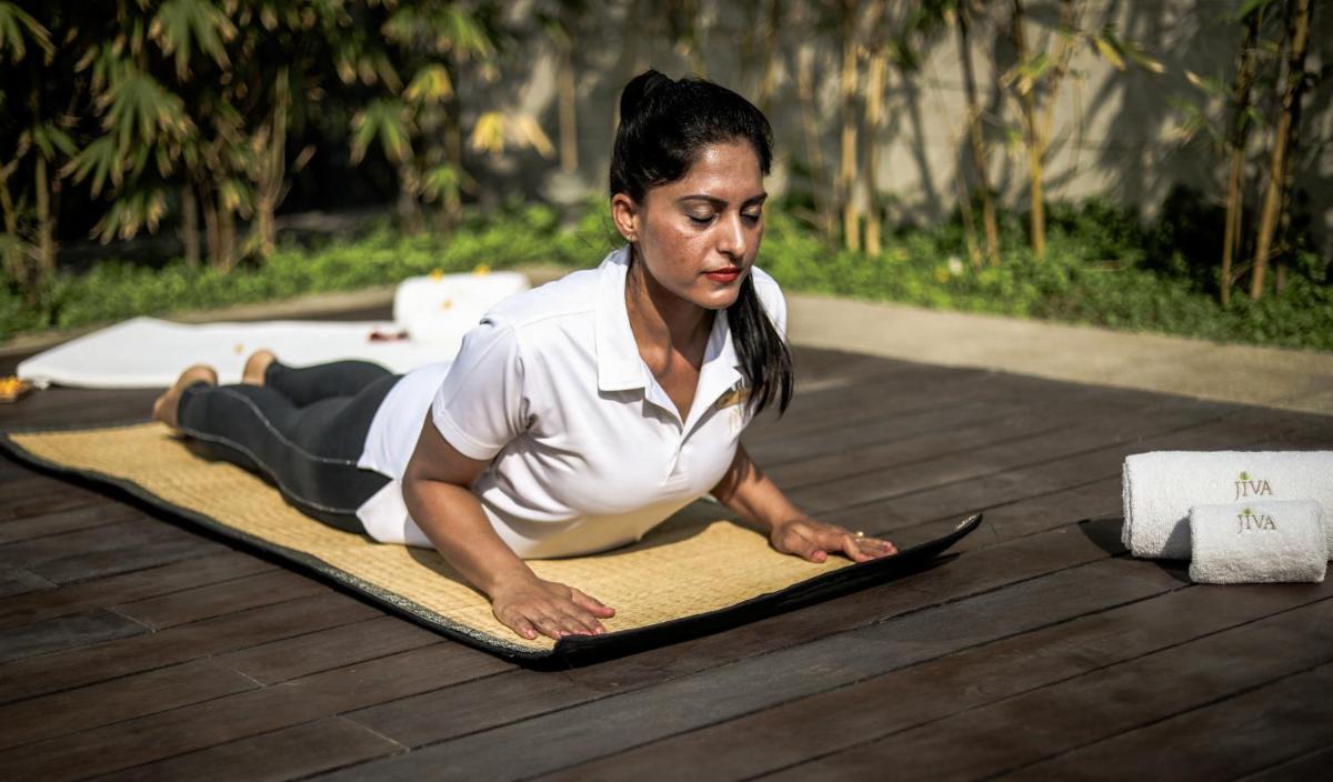 a woman laying on a yoga mat on the floor at Taj City Centre Gurugram in Gurgaon