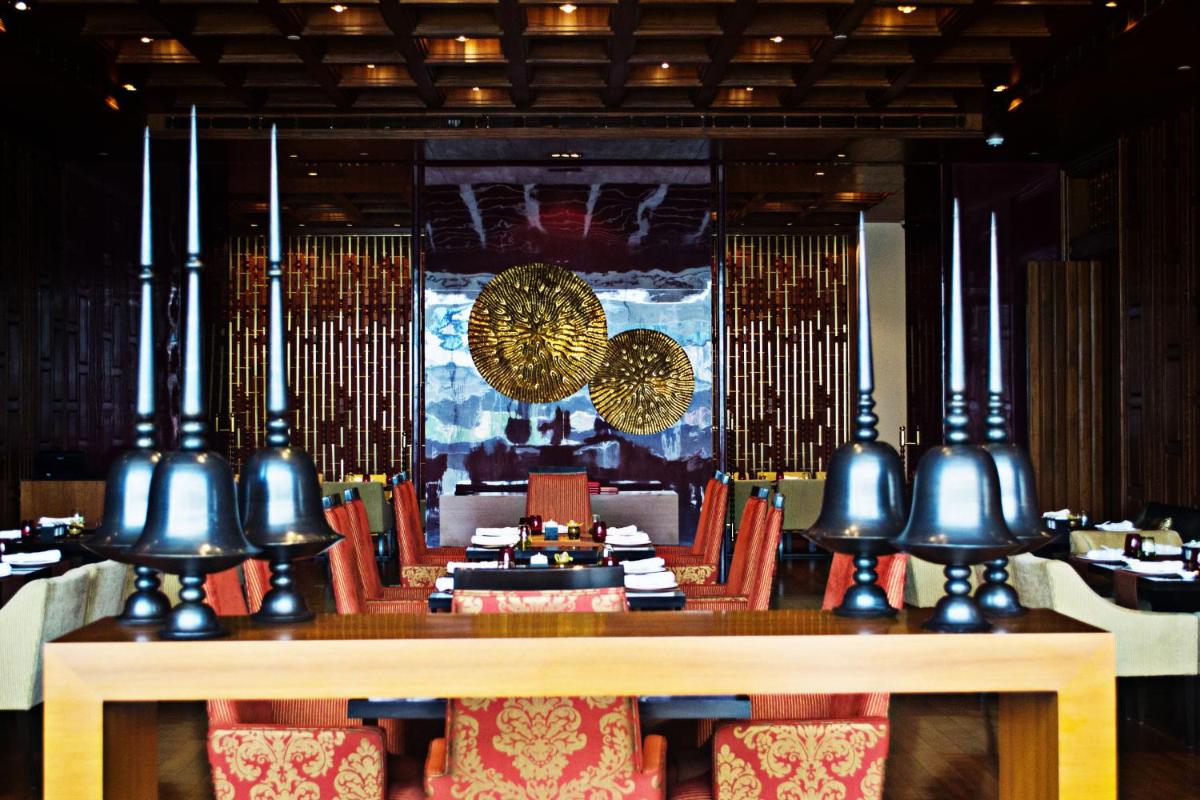 a dining room with a table and chairs and lights at Taj City Centre Gurugram in Gurgaon