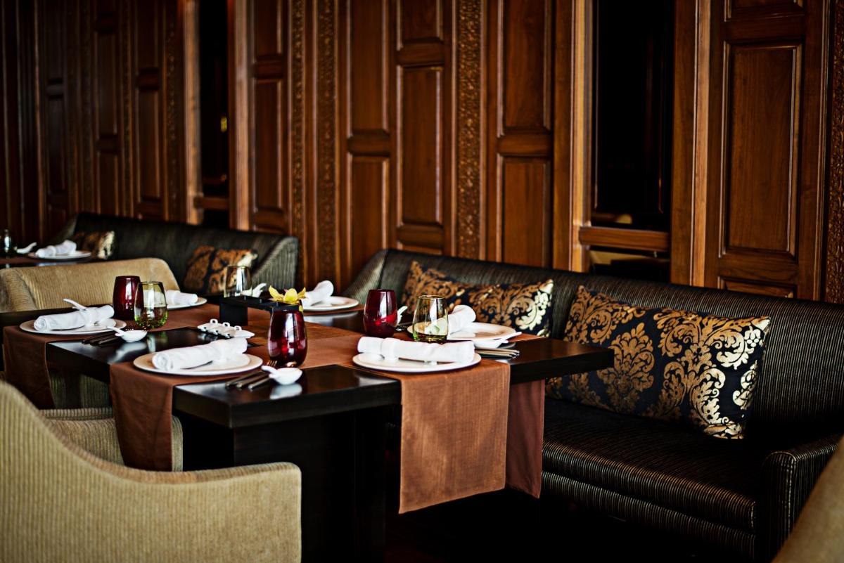 a restaurant with two tables and a couch and chairs at Taj City Centre Gurugram in Gurgaon