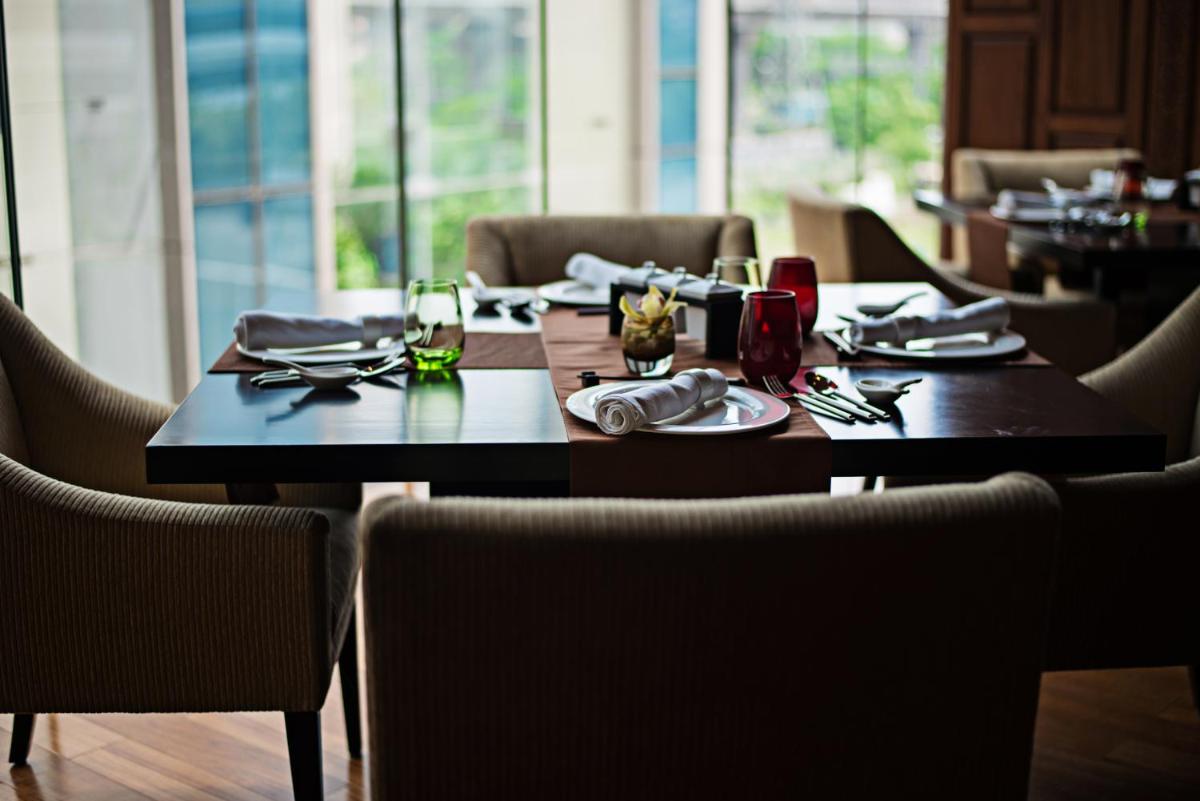 a table in a restaurant with a table set for dinner at Taj City Centre Gurugram in Gurgaon