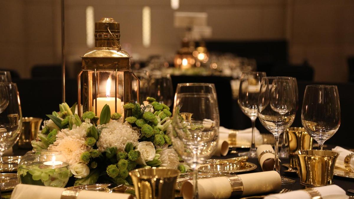a table with wine glasses and a flower arrangement on it at Taj City Centre Gurugram in Gurgaon