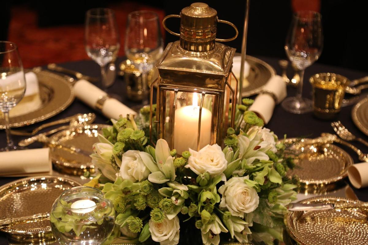 a table with a candle and a centerpiece with roses and flowers at Taj City Centre Gurugram in Gurgaon