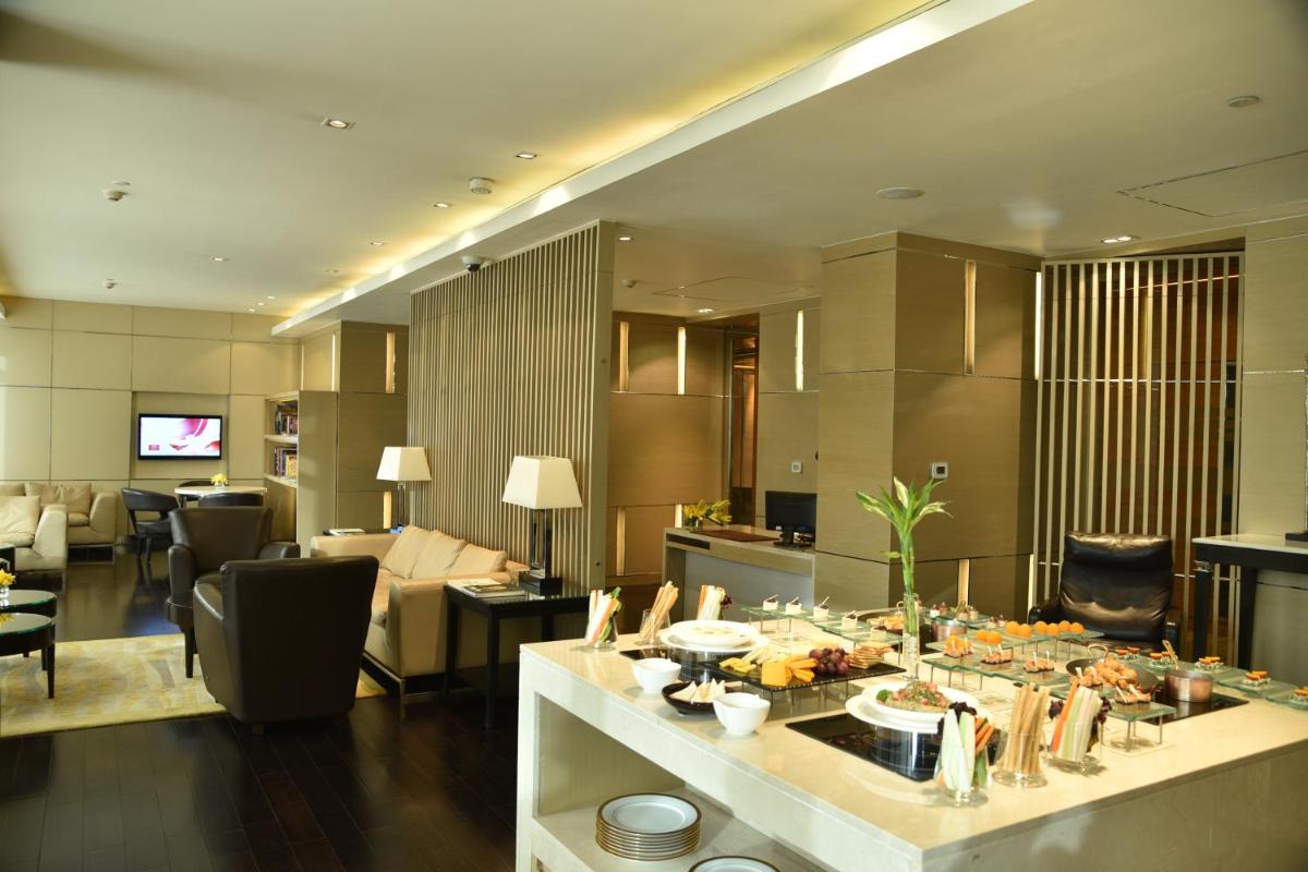 a kitchen and living room with a table with food at Taj City Centre Gurugram in Gurgaon