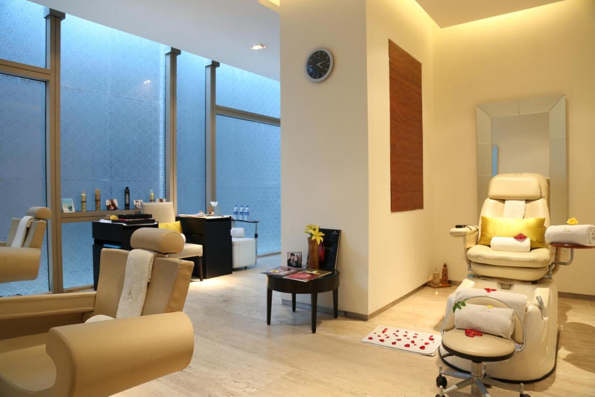 a salon with a waiting room with chairs and a mirror at Taj City Centre Gurugram in Gurgaon