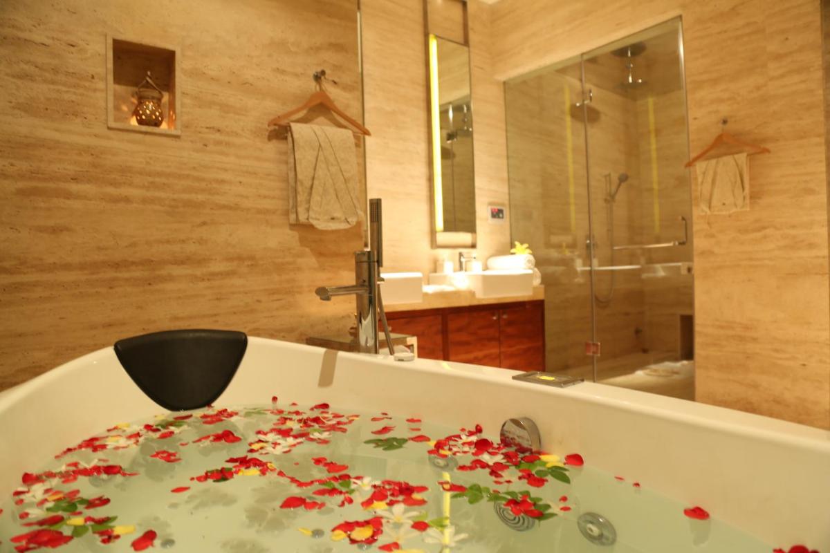 a bathroom with a tub with red flowers on it at Taj City Centre Gurugram in Gurgaon