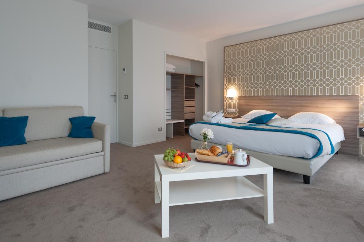 une chambre avec un lit, un canapé et une table dans l'établissement Hotel & Spa Radiana, à La Léchère