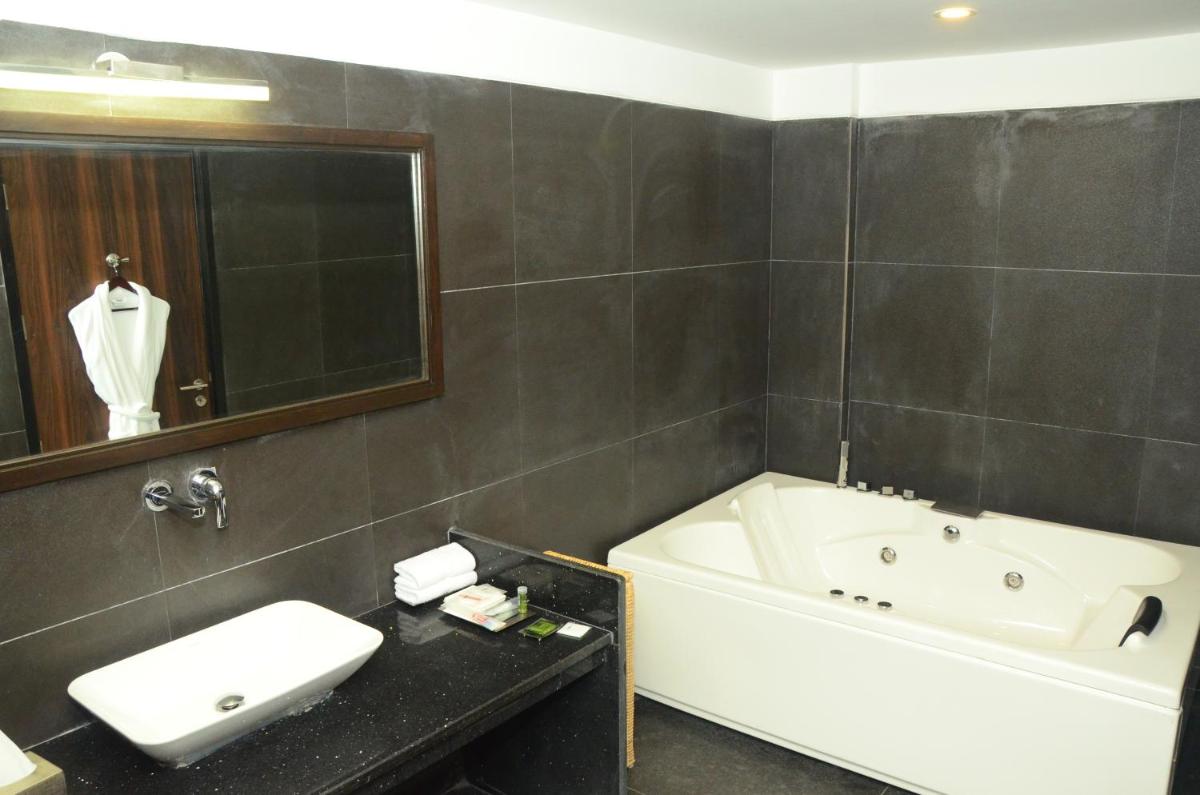 a bathroom with a bath tub and a sink and a bath tub at Radisson Chandigarh Zirakpur in Chandīgarh