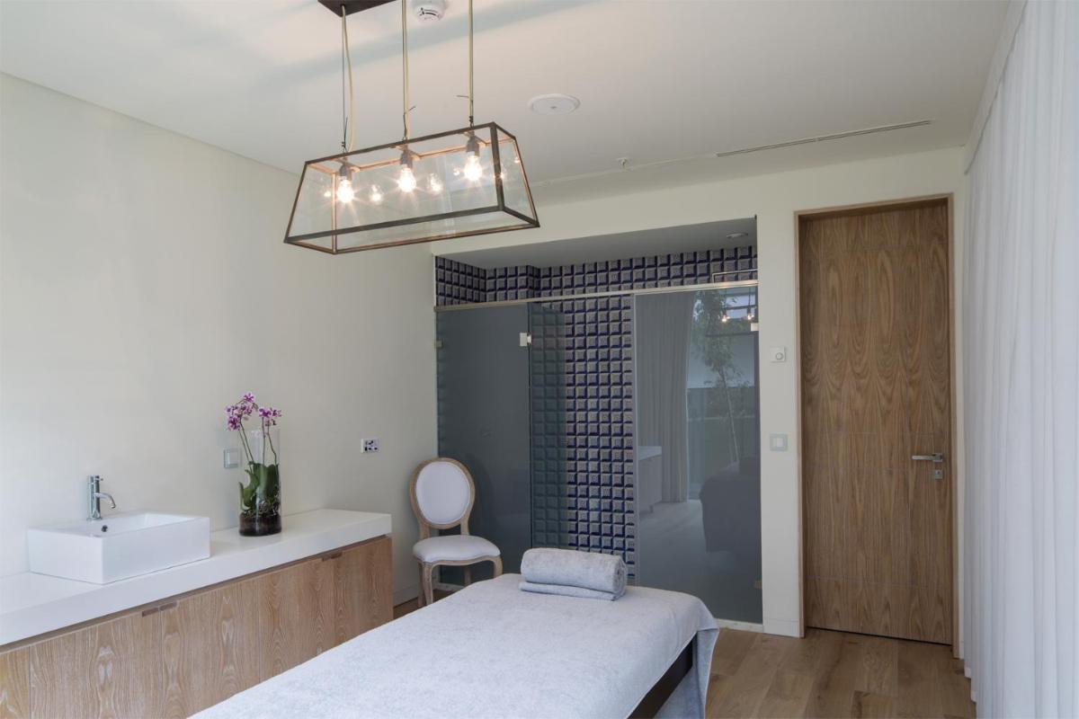 um quarto com uma cama, um lavatório e um espelho em Royal Obidos Scenic Resort em Praia del Rei