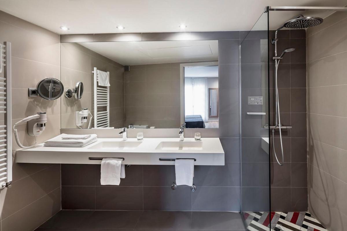 Un baño con lavabo, ducha y espejo. en Balneari Termes Victòria, en Caldes de Montbui