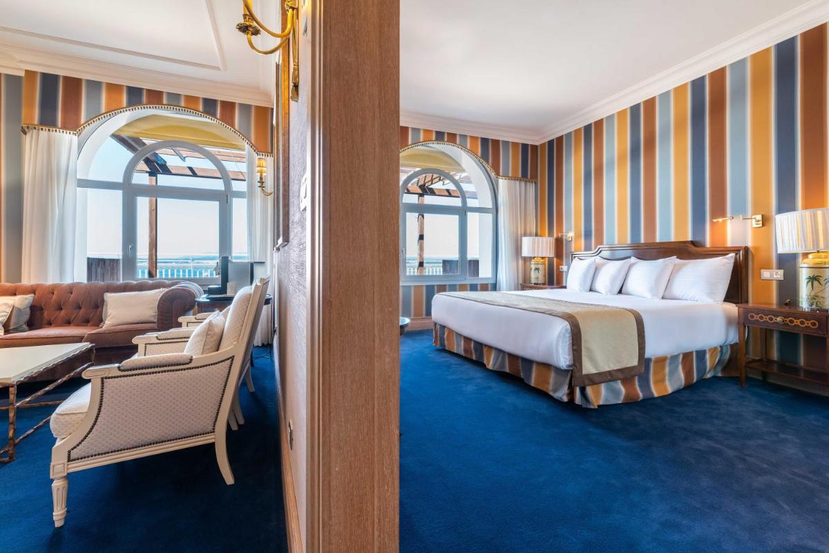 Una habitación de hotel con una cama y una sala de estar. en Eurostars Gran Hotel La Toja, en Isla de la Toja