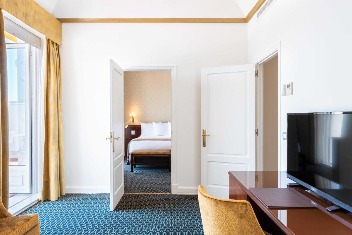 Habitación de hotel con TV y dormitorio en Eurostars Gran Hotel La Toja, en Isla de la Toja