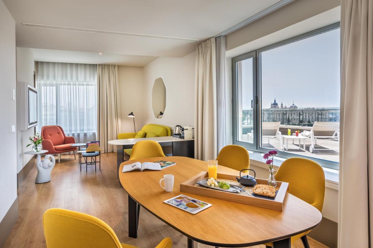 Habitación con mesa, sillas y vistas. en Barceló Torre de Madrid, en Madrid