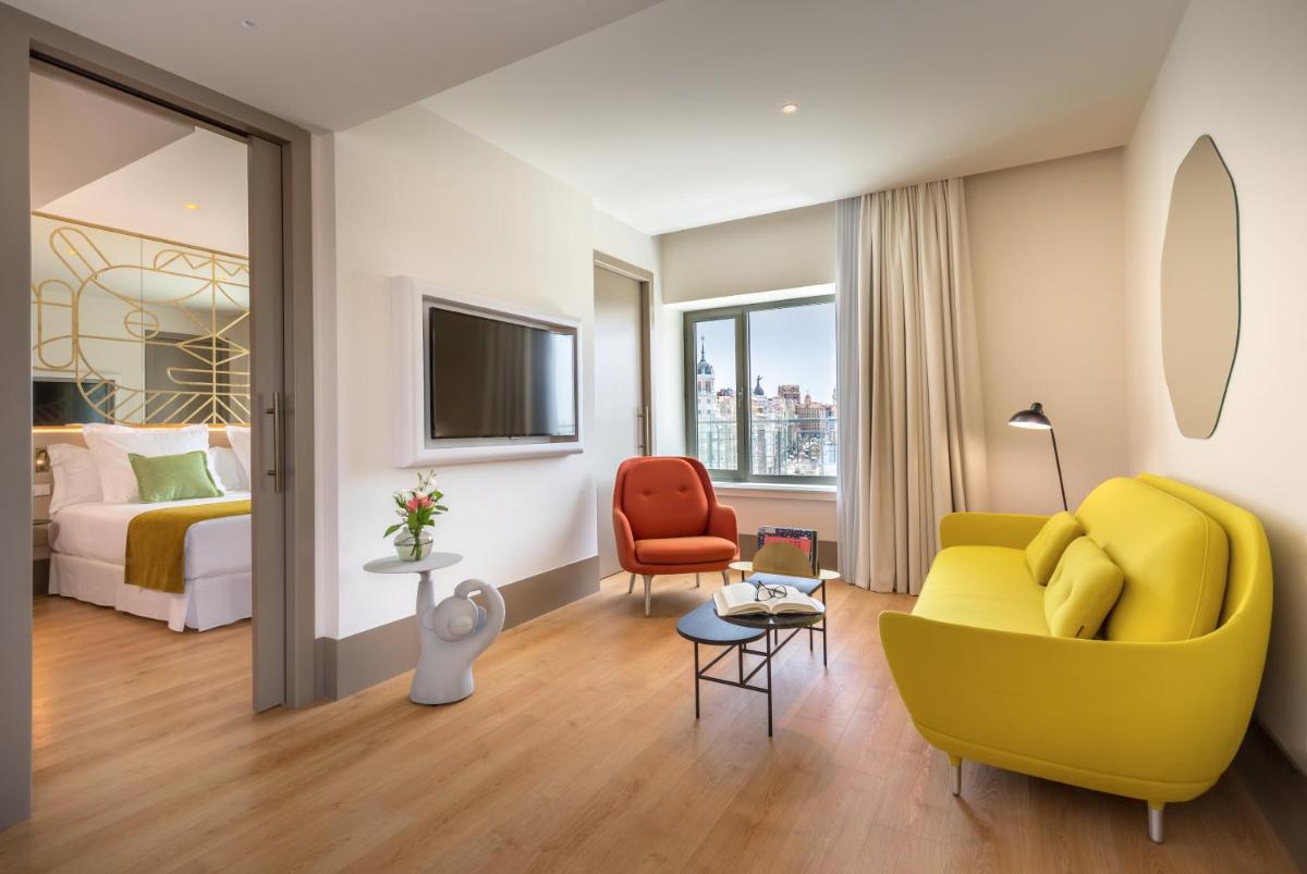 sala de estar con sofá amarillo y silla roja en Barceló Torre de Madrid, en Madrid