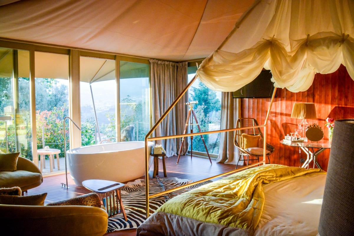 um quarto com uma cama e uma banheira em Carmo's Boutique Hotel - Small Luxury Hotels of the World em Ponte de Lima