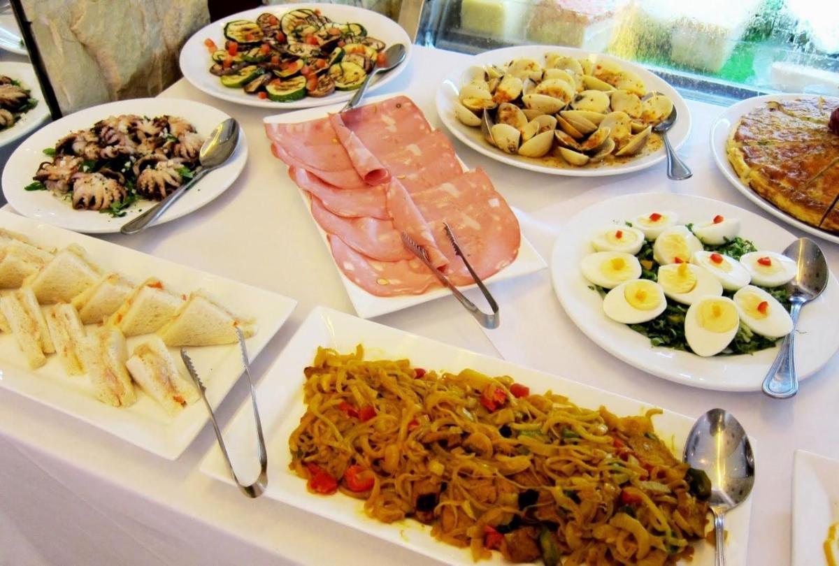 a table with many plates of food on it at Jai Mahal Palace in Jaipur