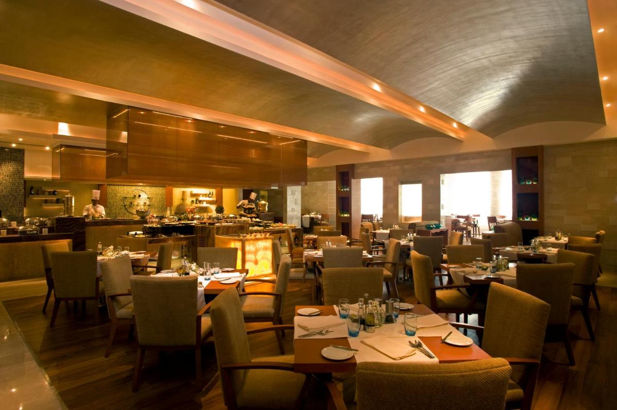 a dining room with tables and chairs in a restaurant at Taj Coromandel in Chennai