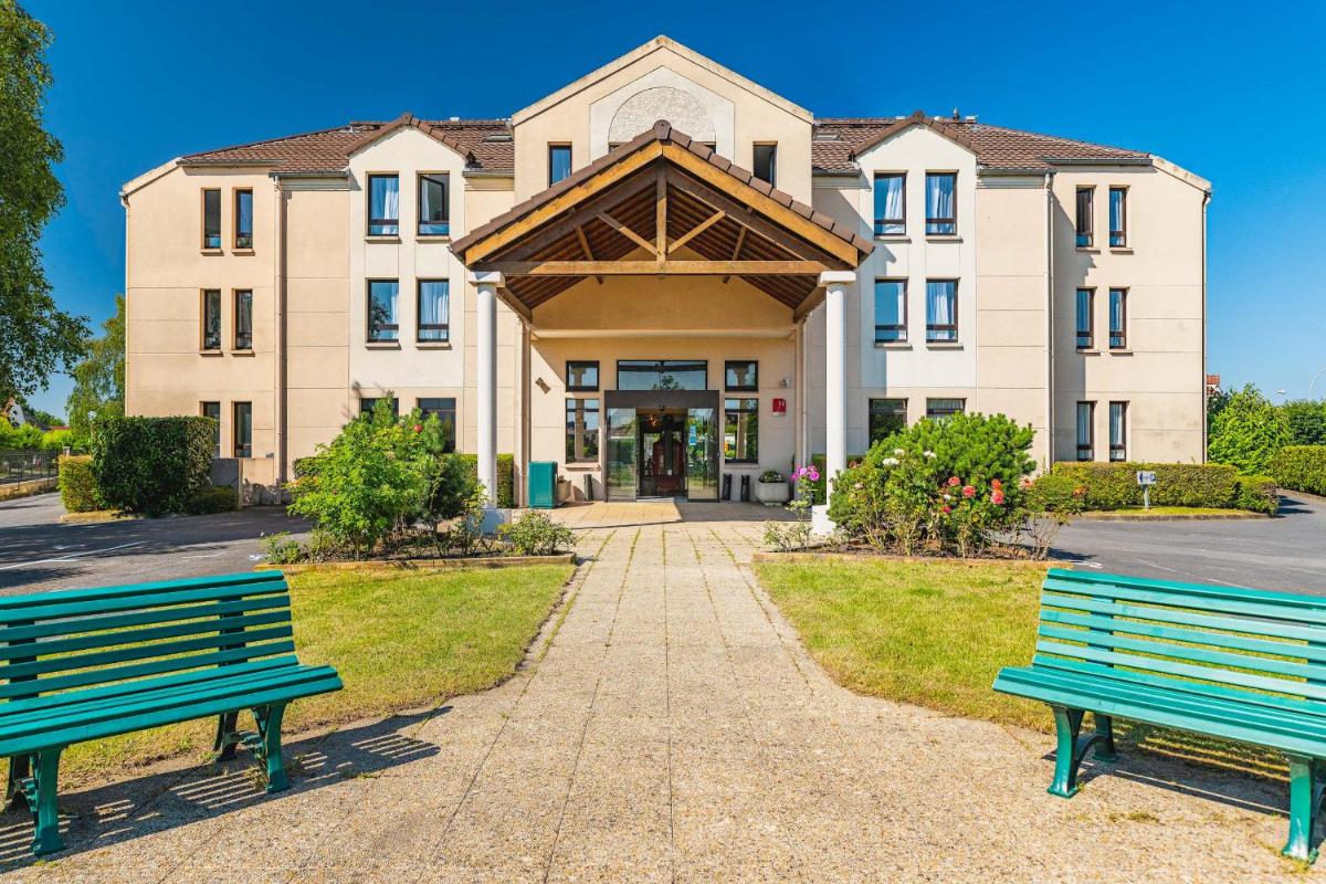 deux bancs verts devant un bâtiment dans l'établissement Best Western Hôtel Grand Parc Marne La Vallée, à Chanteloup-en-Brie
