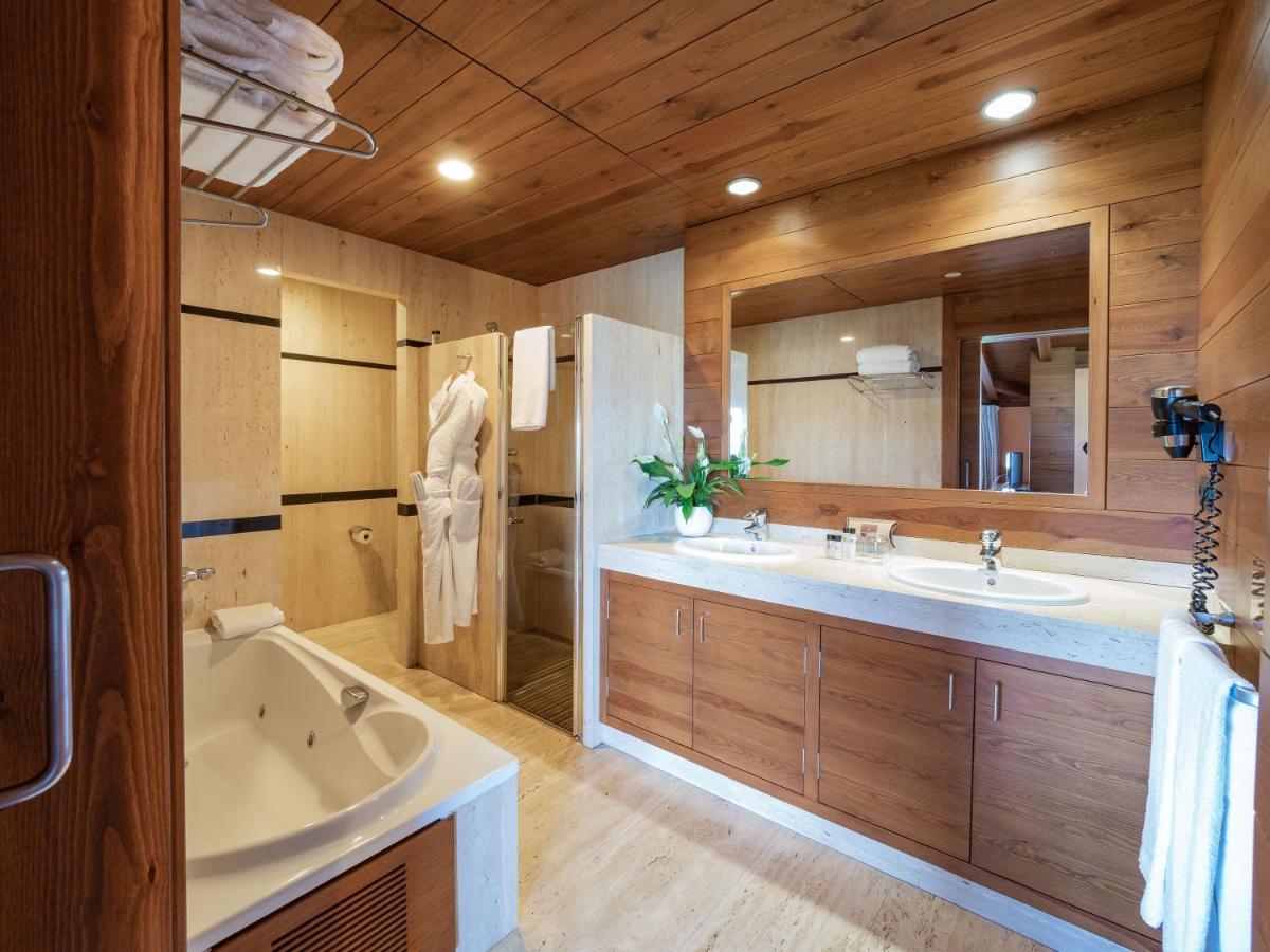 Un baño con dos lavabos, una bañera y un espejo grande. en Montanyà, en Seva
