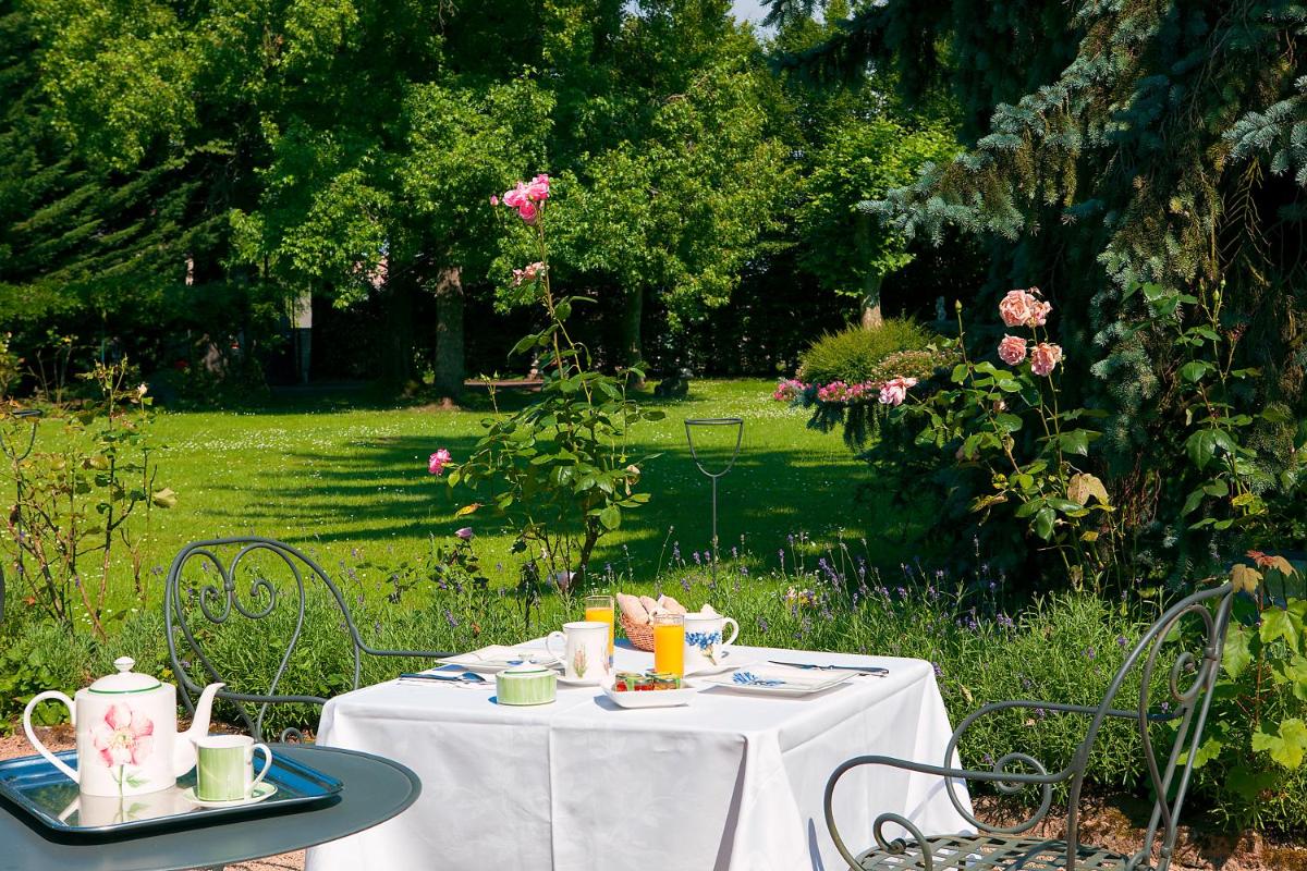 une table avec une nappe blanche et des tasses à thé dessus dans l'établissement Château de Fleurville & Spa, à Fleurville