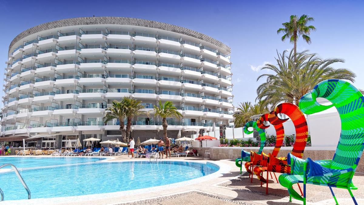 Un complejo con piscina y un gran edificio. en Bull Escorial & SPA, en Playa del Inglés