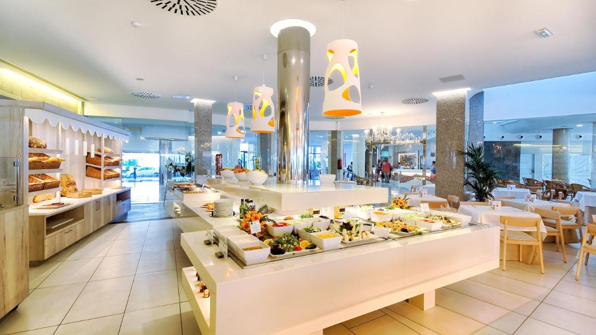 Un restaurante con un buffet de comida en exhibición. en Bull Escorial & SPA, en Playa del Inglés
