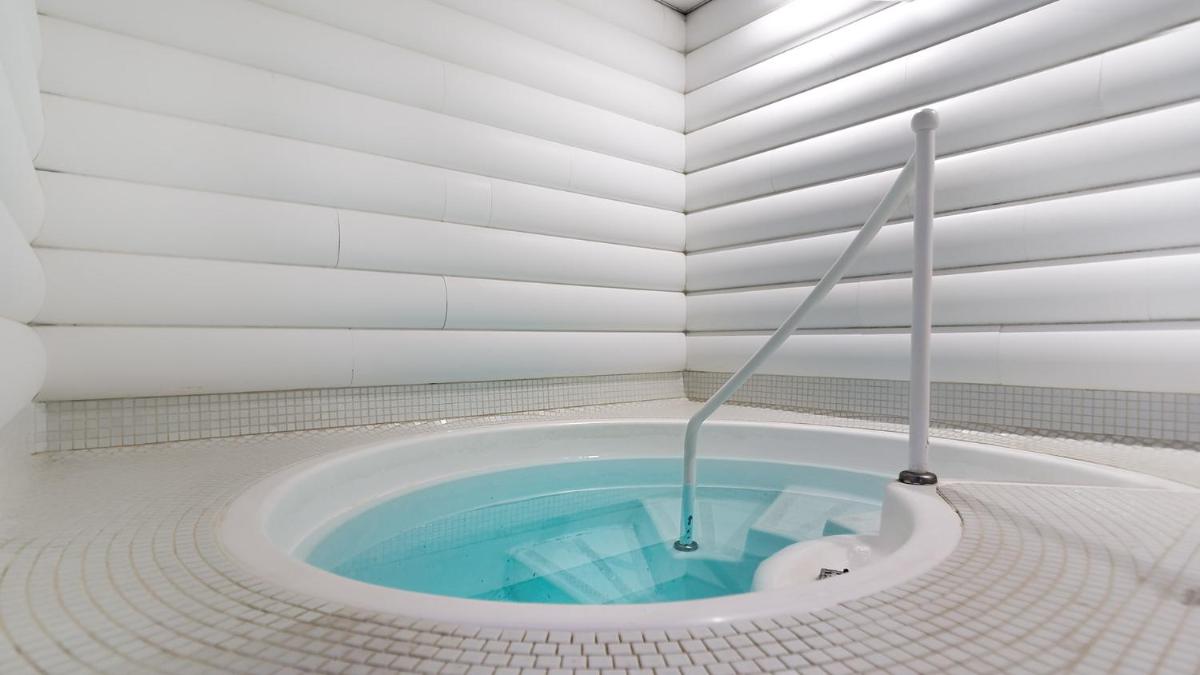 - Baño con bañera y piscina azul en Bull Dorado Beach & SPA, en La Playa de Arguineguín