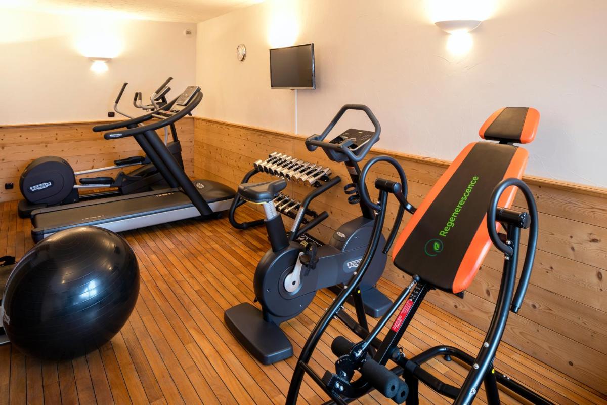 - une salle de sport avec deux vélos d'exercice et un tapis de course dans l'établissement Carlina, à La Clusaz