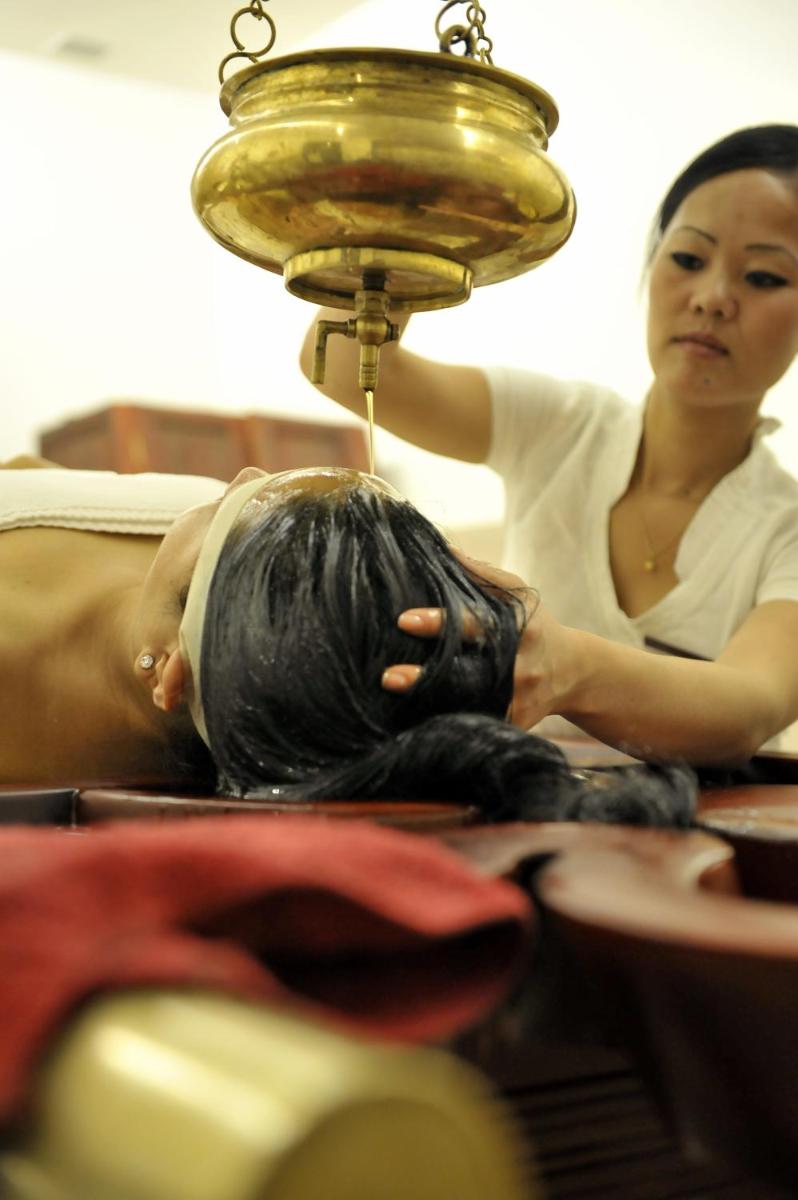a woman getting her hair cut by a hair drier at The Oterra in Bengaluru