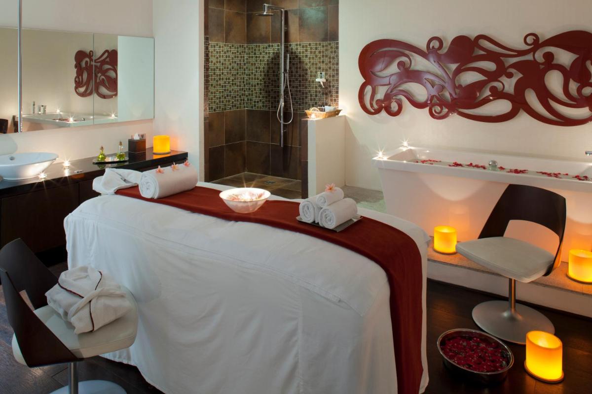 a bathroom with a bed and a shower with candles at The Oterra in Bengaluru