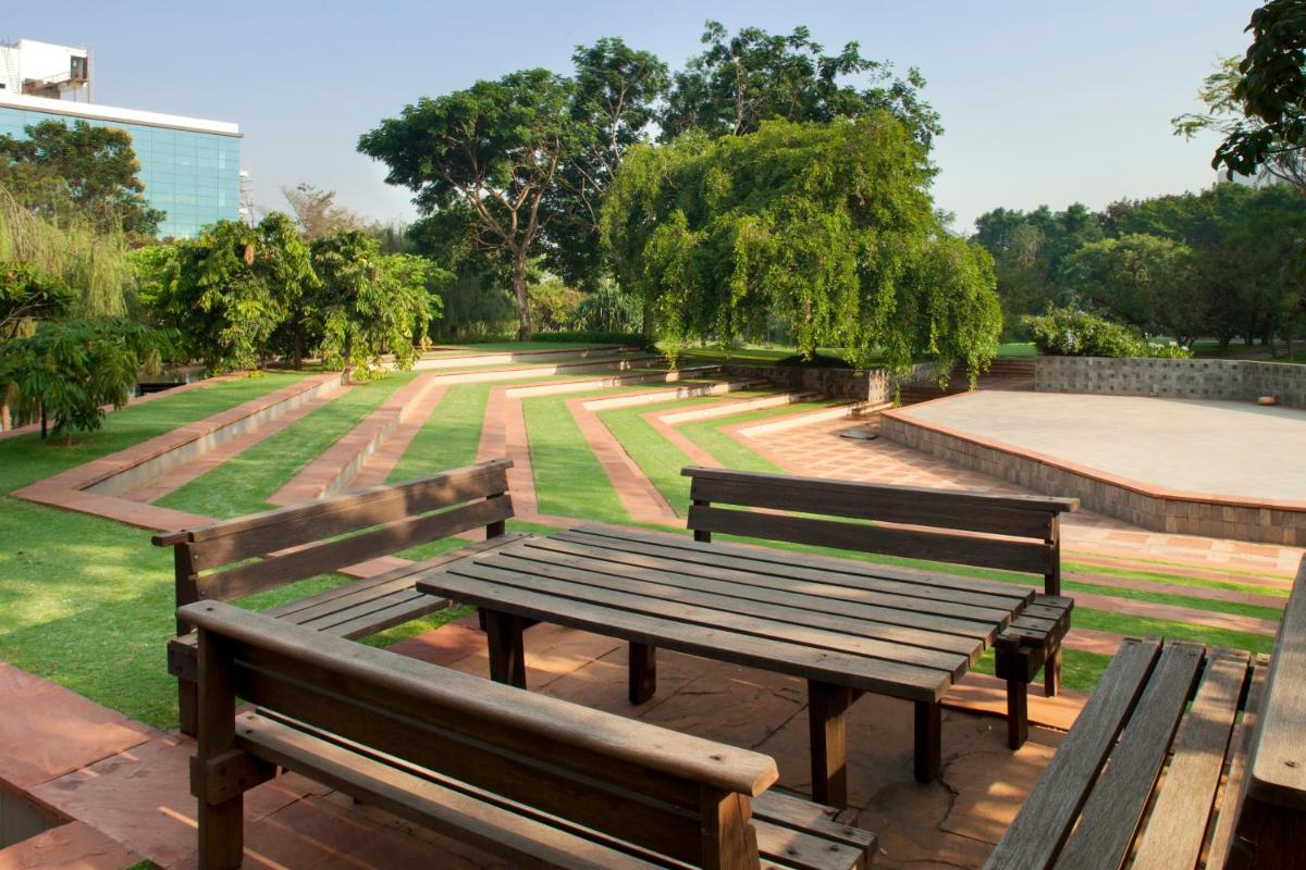 a row of wooden benches in a park at The Oterra in Bengaluru