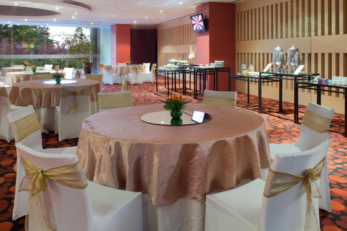 a banquet room with tables and white chairs and tablesearcher at The Oterra in Bengaluru
