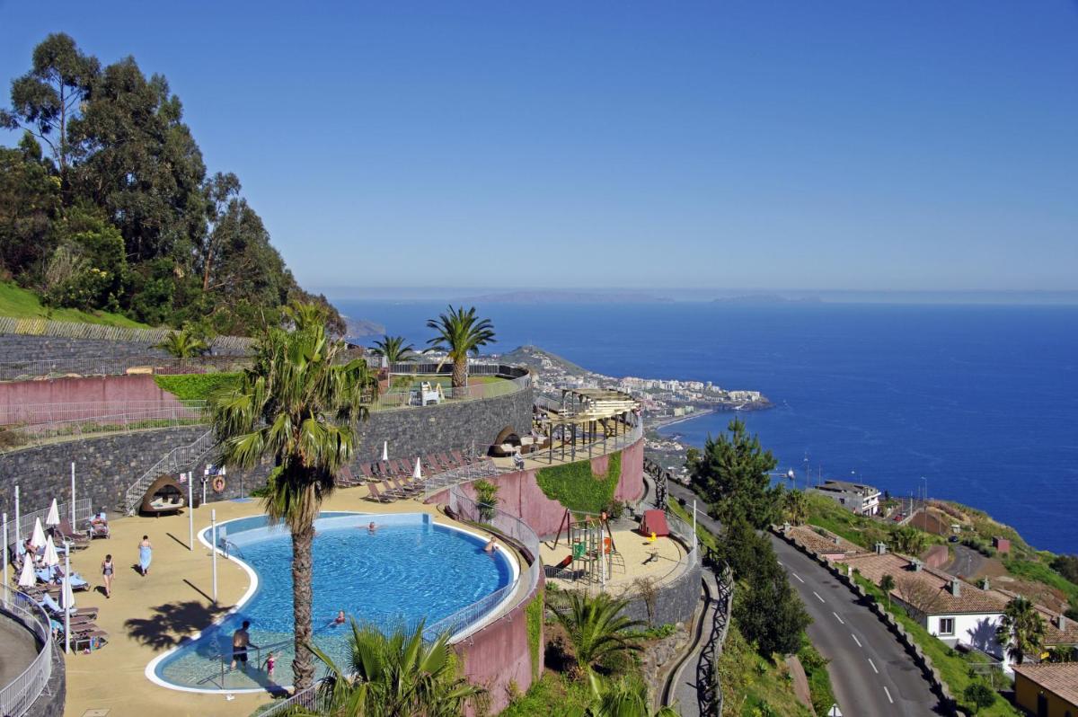 uma vista para uma piscina junto ao oceano em Village Cabo Girao em Câmara de Lobos