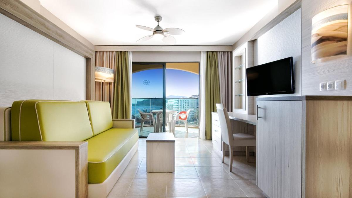 sala de estar con sofá amarillo y TV en Bull Dorado Beach & SPA, en La Playa de Arguineguín