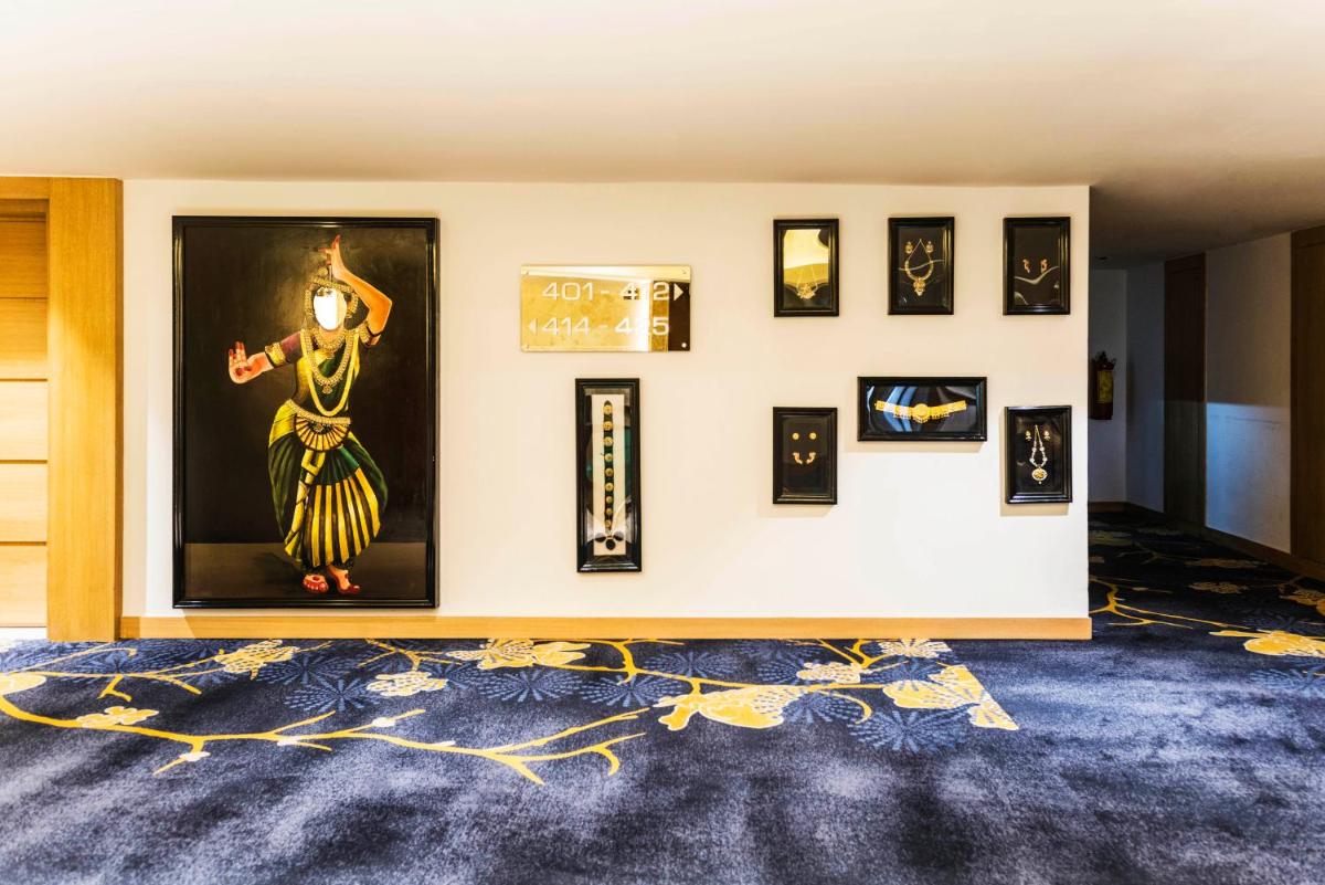 a wall with framed pictures on a wall at Grand Chennai by GRT Hotels in Chennai
