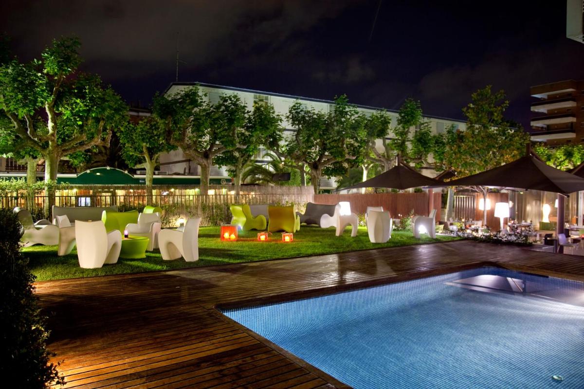 un resort con piscina por la noche en Magnolia Hotel - Adults Only, en Salou