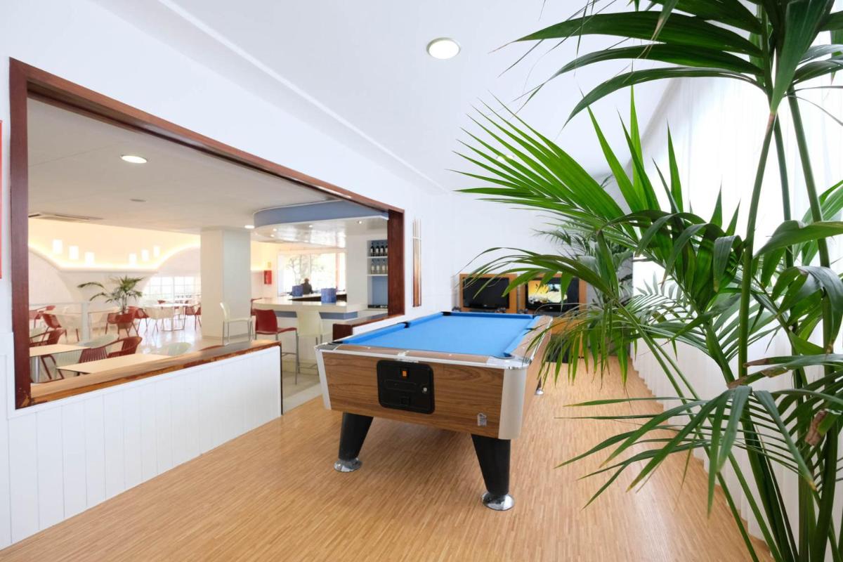 una mesa de billar en una sala de estar con plantas en azuLine Hotel Bergantin, en Bahía de San Antonio