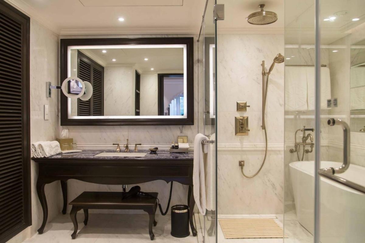 a bathroom with a sink and a shower and a mirror at Taj Bengal in Kolkata