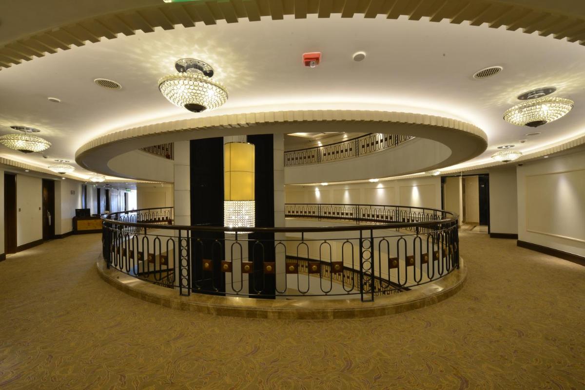 a large lobby with a circular ceiling with lights at Ramada Plaza Chennai in Chennai