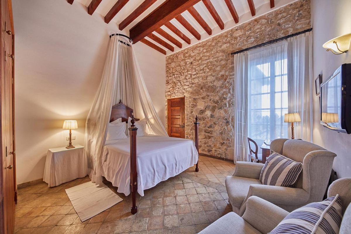 Un dormitorio con una cama, un sofá y una silla. en Cas Comte Suites & Spa - Adults Only, en Lloseta 244 fotos más