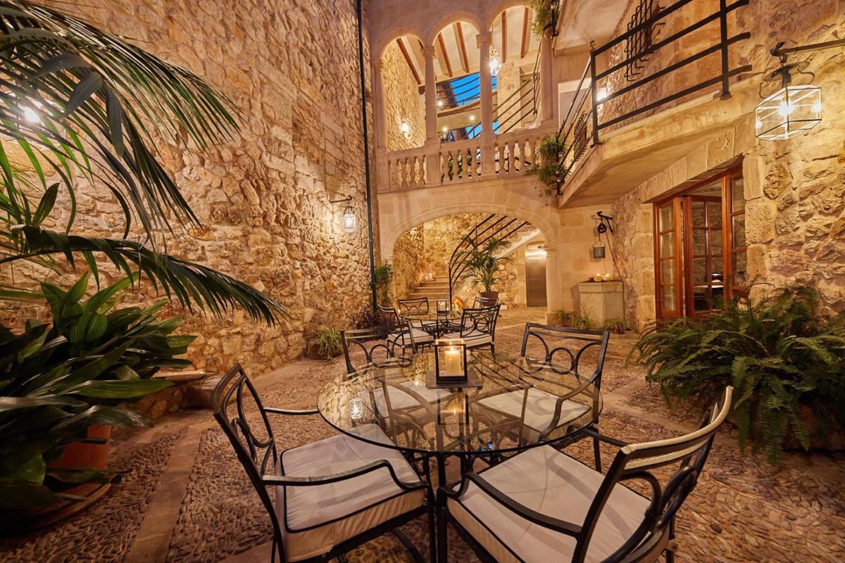 Un comedor con una mesa de cristal y sillas. en Cas Comte Suites & Spa - Adults Only, en Lloseta
