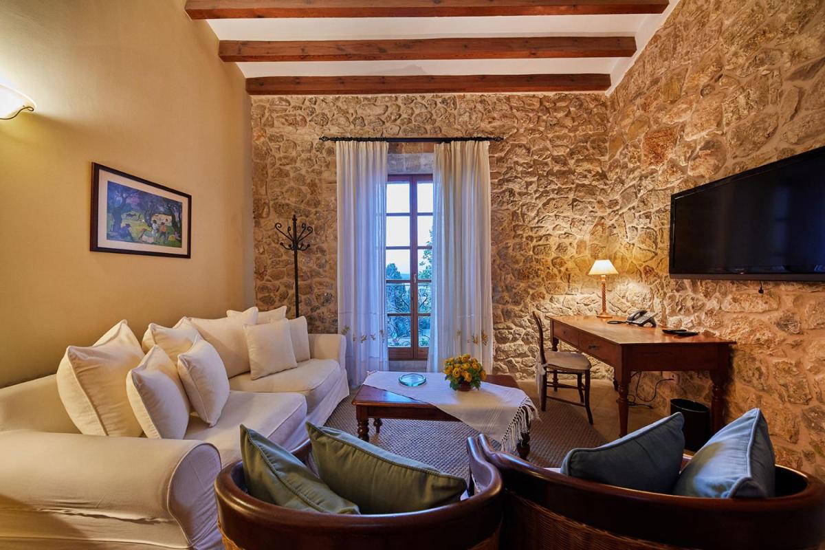 Una sala de estar con sofás y sillas y un televisor. en Cas Comte Suites & Spa - Adults Only, en Lloseta