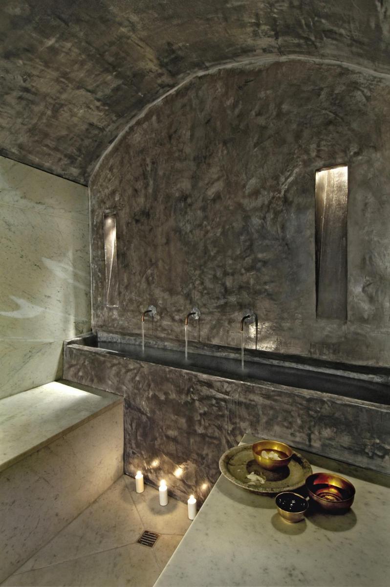 La salle de bains est pourvue d'un lavabo et d'une table avec des bougies. dans l'établissement L'Hôtel Particulier, à Arles