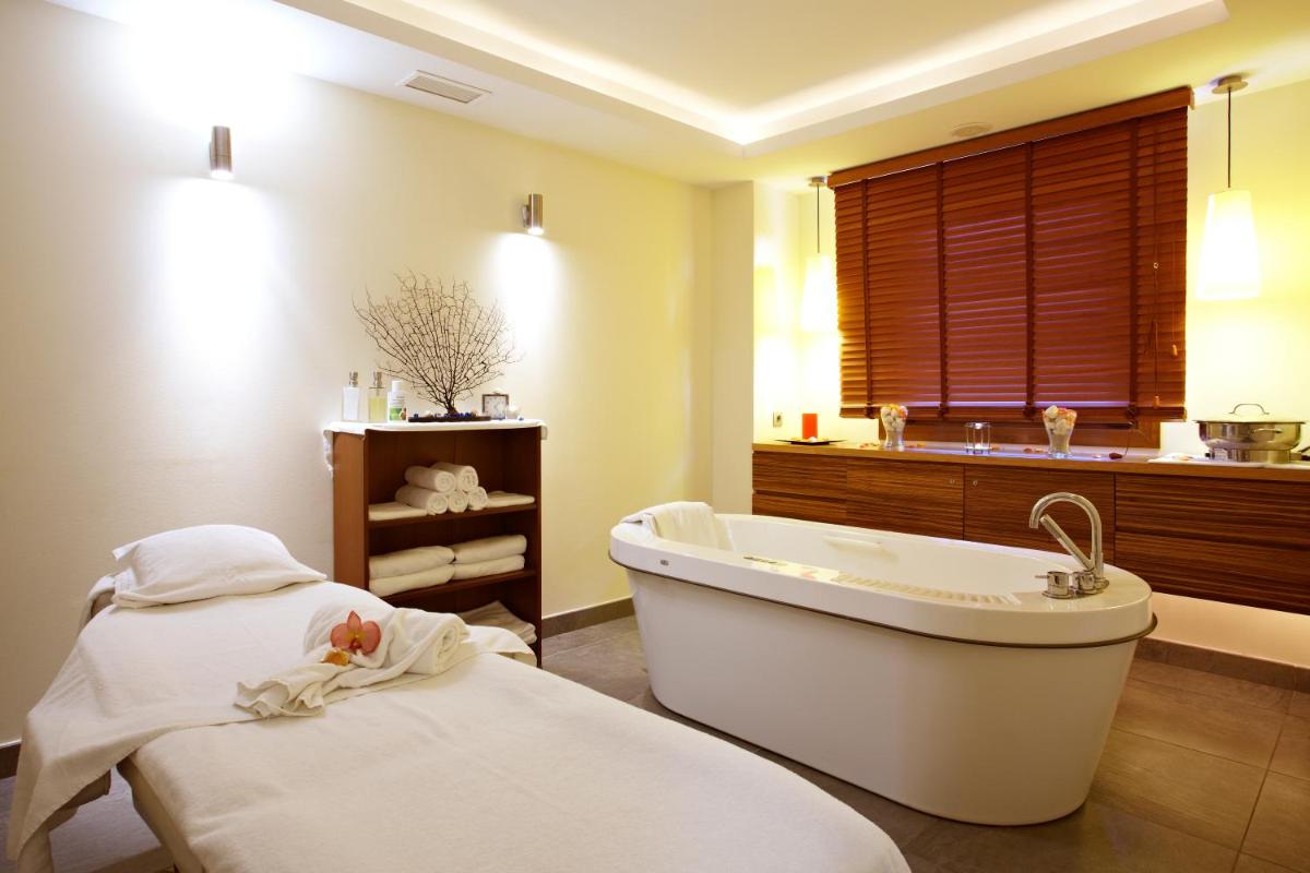 y baño con bañera y 2 camas. en Grupotel Aguait Resort & Spa - Adults Only, en Cala Ratjada